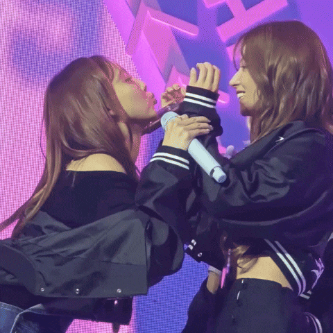a couple of women standing next to each other with a microphone