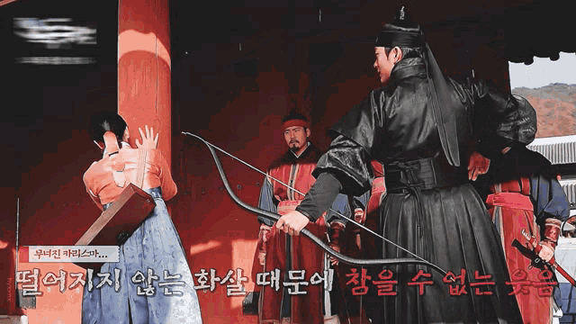 a man in a black robe is holding a bow and arrow while standing next to a woman