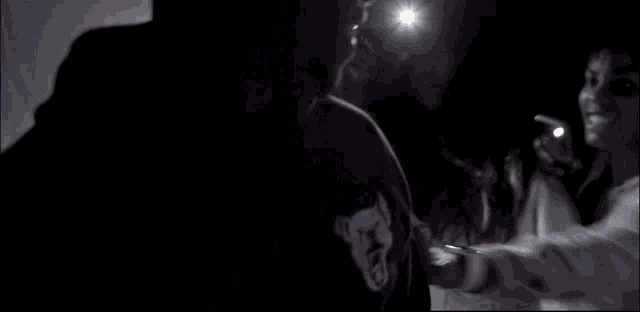 a man and a woman are standing next to each other in the dark .