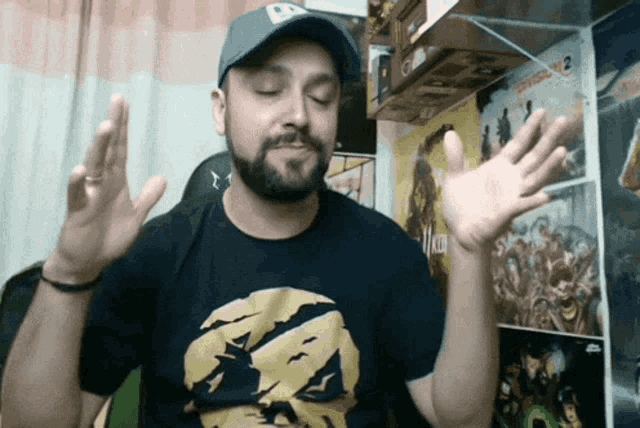 a man with a beard wearing a hat and a black shirt with a picture of a skull on it