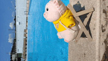 a stuffed pig wearing a yellow scarf sits on a beach chair near a swimming pool