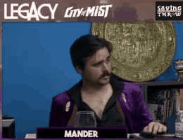 a man in a purple suit is sitting at a desk with a name plate that says mander