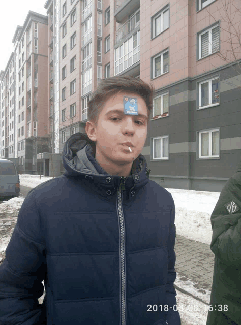 a young man has a sticker on his forehead that says ' i 'm sorry '