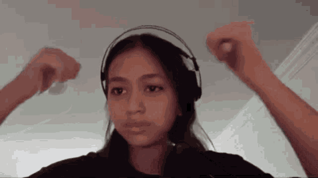 a girl wearing headphones is making a face