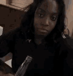 a woman is holding a piece of paper in her hand and making a funny face .