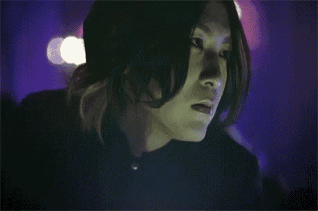 a close up of a person 's face with purple lights behind them