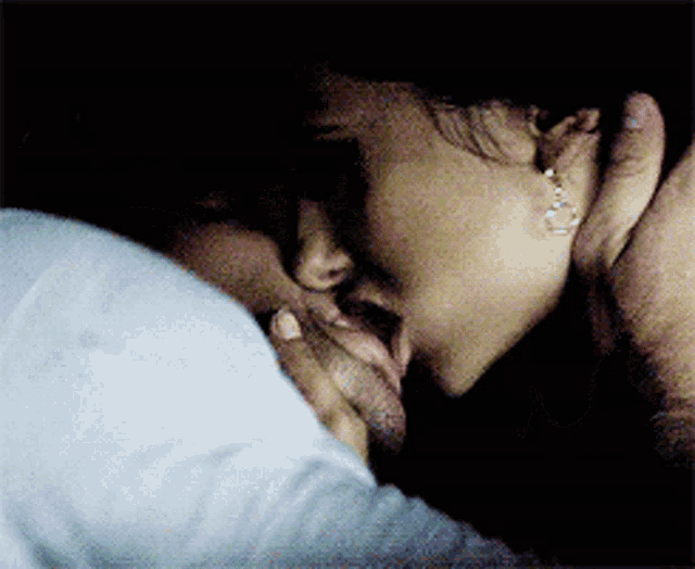 a close up of a woman kissing a man 's face