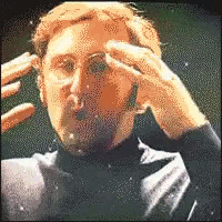 a pixelated image of a man with glasses holding his head