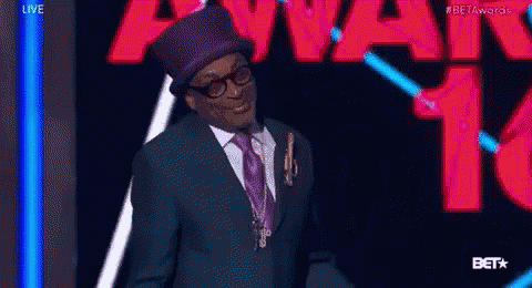a man in a suit and top hat is standing in front of a sign that says beta awards .