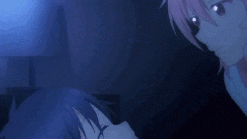 a girl with pink hair is laying on a man 's chest .