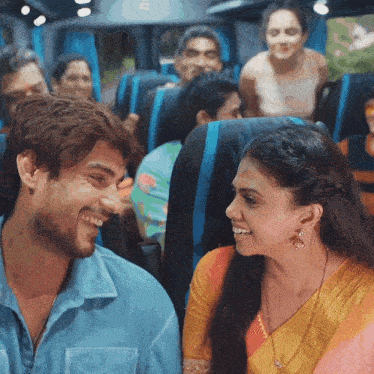 a man and a woman are smiling while sitting on a bus