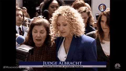 a woman named judge albracht is being interviewed by a group of reporters