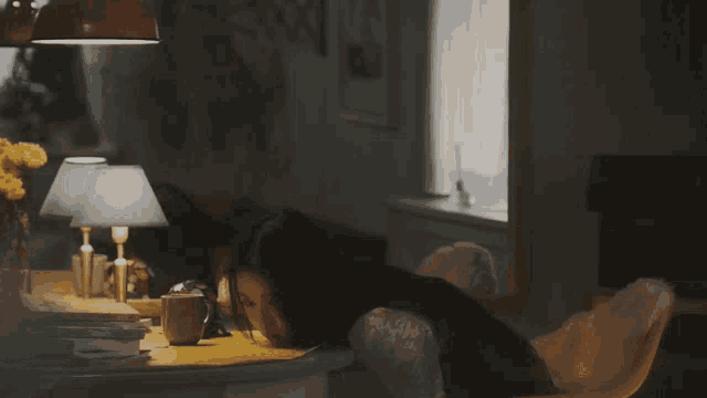 a woman sits at a table with a cup of coffee in front of her
