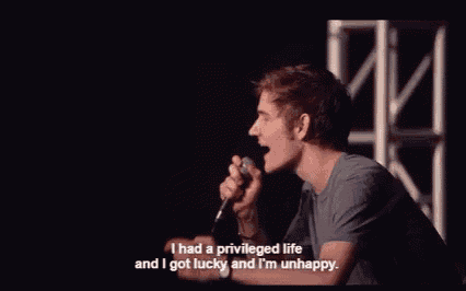 a man is talking into a microphone and says i had a privileged life and i got lucky