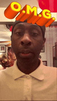 a man wearing a white shirt has the letters omg on his head