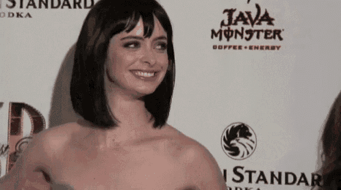 a woman is smiling in front of a sign that says java monster on it