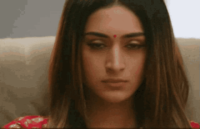 a woman has a red dot on her forehead