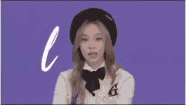 a girl wearing a beret and a bow tie is standing in front of a purple background that says las n
