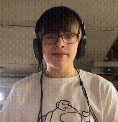 a young boy wearing headphones and glasses is looking at the camera