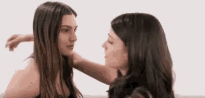 two women are hugging each other and looking at each other 's faces .