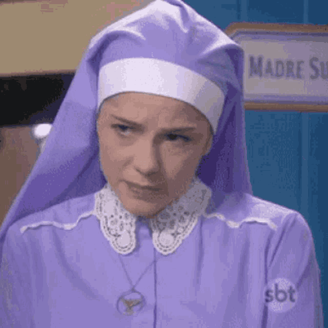 a woman in a purple nun costume is standing in front of a door .