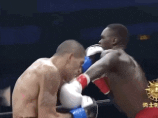 two men are boxing in a ring and one of them has a red cup in his hand