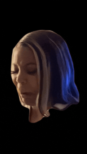 a close up of a woman 's face with her eyes closed against a black background