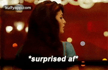 a woman is standing in front of a red background and saying `` surprised at '' .