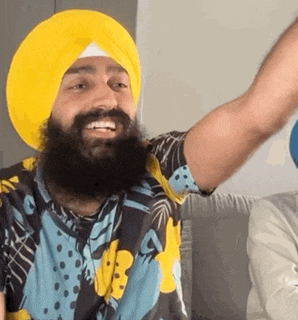 a man with a beard wears a yellow turban