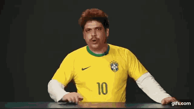 a man wearing a yellow soccer shirt with the number 10 on it