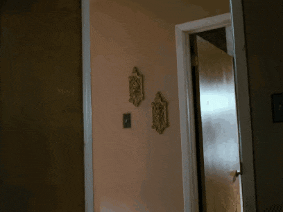 a door is open to a hallway with a clock on the wall