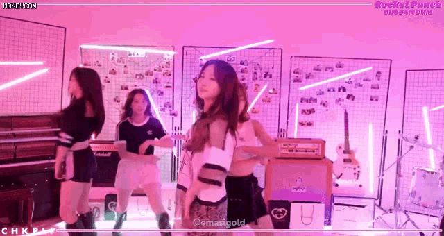 a group of girls are dancing in a room with purple lights and a sign that says rocket punch on it
