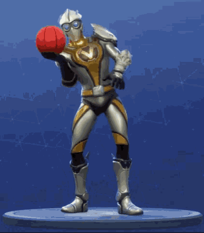 a man in a superhero costume is holding a red ball in his hand .