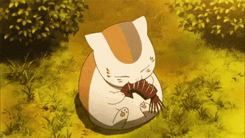a cat is sitting in the grass and eating a piece of food .