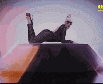 a pixelated image of a woman laying on a box with the letter g on the bottom right
