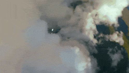 a plane is flying through a cloudy sky with a white object in the middle