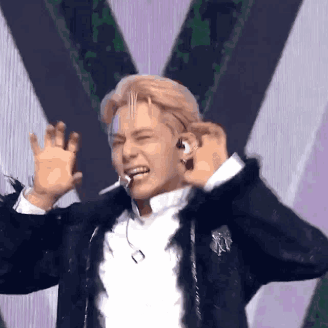 a man wearing a black jacket and a white shirt is making a funny face .