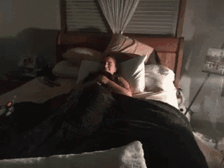 a woman laying in a bed with a black blanket