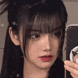 a close up of a girl taking a selfie in a mirror .