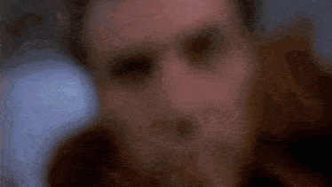 a close up of a man 's face with glowing eyes and a blurred background
