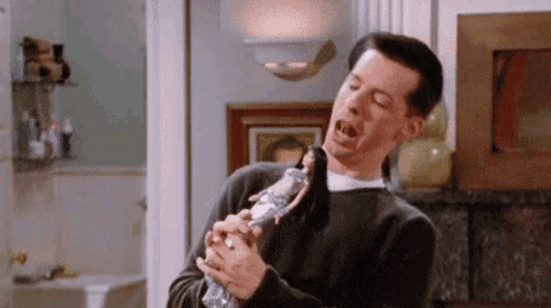 a man is holding a barbie doll in his hands while making a funny face .