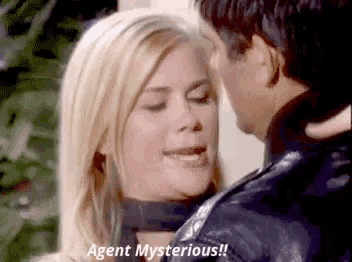 a man is kissing a woman on the forehead and says agent mysterious .