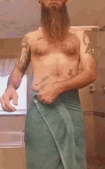 a shirtless bearded man wrapped in a green towel