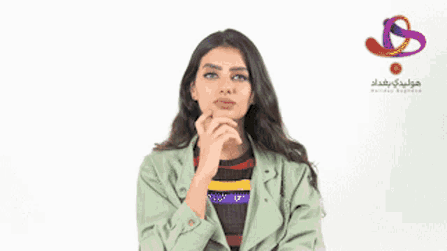a woman in a green jacket is looking up with a holiday resort logo behind her