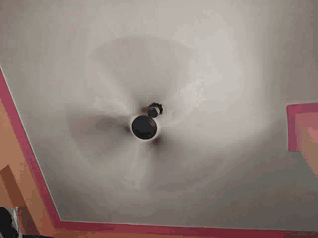 a ceiling fan is on a white ceiling with a pink border
