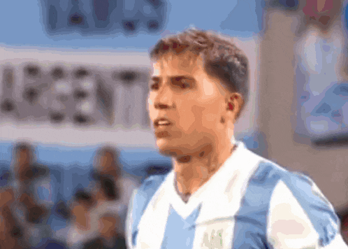 a man in a blue and white striped shirt stands in front of a banner that says argentina