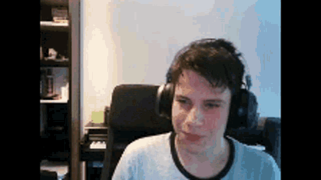 a man wearing headphones is sitting in a chair looking at the camera