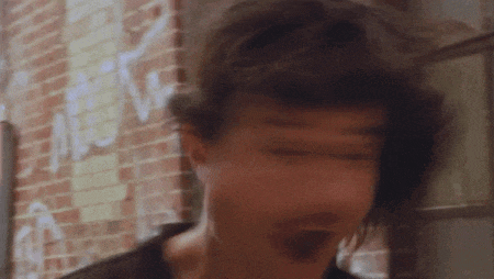 a blurry picture of a man 's face against a brick wall .