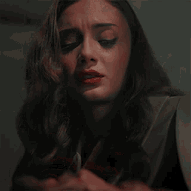 a close up of a woman 's face with her eyes closed and red lips
