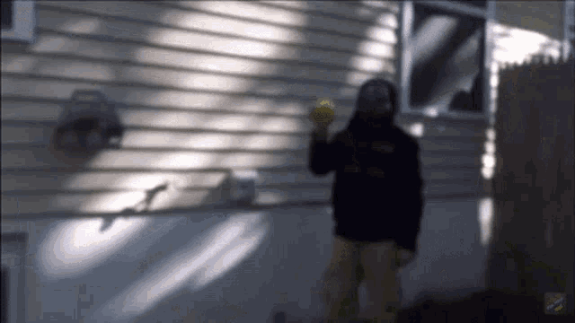 a blurry picture of a person throwing a ball in front of a house with a youtube logo on the bottom right